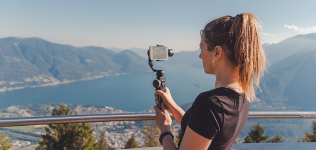 girl using a phone stabilizer while videoing mountains girl taking photo of mountain scape